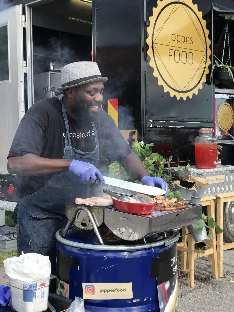 Joppe skär fläsksida på grillen vid vagnen